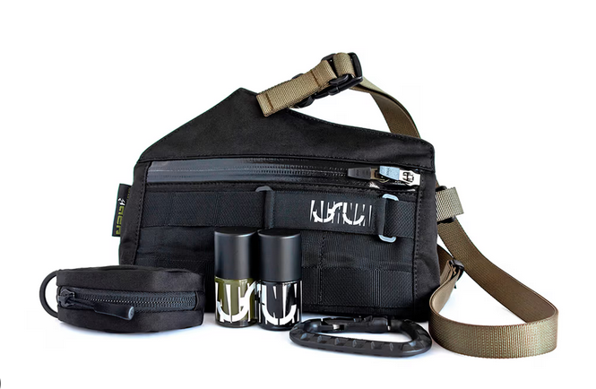 Acronym bag with two uslu airlines nail polish bottles matching the black colour of the bag and a dark bronze for the strap